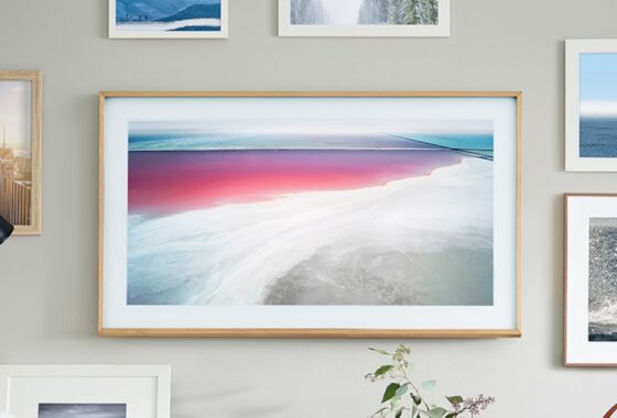 Samsung’s The Frame TV hanging on a wall with a photo of a beach scene on the screen.