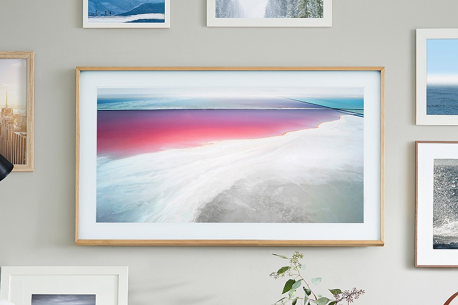Samsung’s The Frame TV hanging on a wall with a photo of a beach scene on the screen.