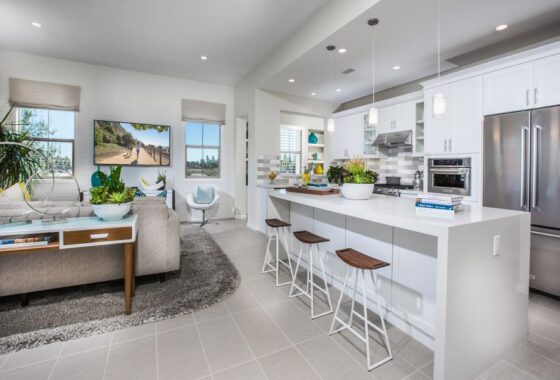 Brightly lit white kitchen with raised shades and a flat-screen TV with an image of runners.